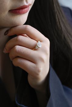 a close up of a person wearing a ring with a diamond on it's finger