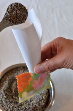 a person is holding a paper and spoon over some food in a small bowl on the table