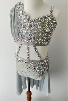 a dress with silver sequins on the top and bottom, sitting on a mannequin