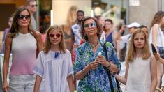 a group of women walking down a street next to each other