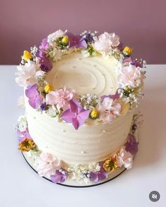 a white cake with flowers on it sitting on a table