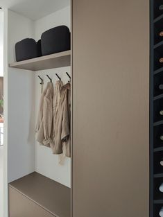 a closet with several coats hanging on the wall