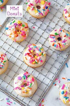 sprinkle covered donuts on a cooling rack