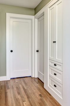 an empty room with white closets and wood floors