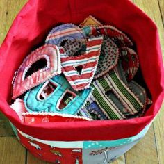 a red bag filled with lots of different types of ties on top of a wooden floor