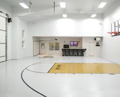 an indoor basketball court with white walls and yellow flooring is shown in this image