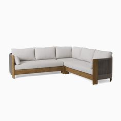 the sectional sofa is made out of wood and has white linen on it's back