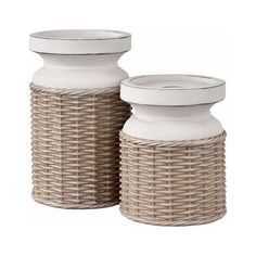 two white vases sitting next to each other on top of a wooden table with wicker baskets