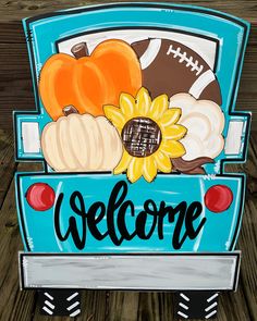 a welcome sign with sunflowers, pumpkins and football on the back of a truck