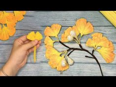 someone is making yellow flowers out of paper