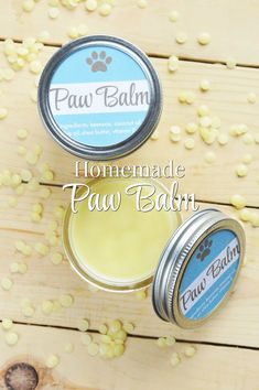 two small tins of paw balm sitting on top of a wooden table with the words, diy homemade paw balm