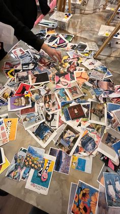 a table topped with lots of different pictures and papers on top of eachother