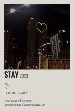 an advertisement with the words stay written on it in front of some tall buildings at night