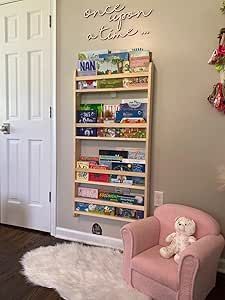 a pink chair sitting in front of a book shelf filled with children's books