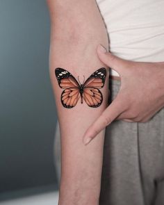 a woman's arm with a butterfly tattoo on the left side of her body