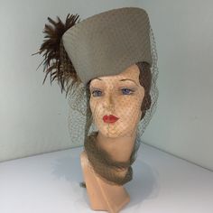 "Circa:  1940s  Well whaaaaat is this beauty?? Tall as it goes and what a statement! Taupe velour toque hat with one tone darker veil that wraps about the neck, draping ever so beautifully. A massive rust plume off to one side to just say \"Take a look but not too long, I charge for the look\" DO YOU ACCEPT OFFERS? We do NOT accept offers or negotiate on pricing. We do offer layaways and have sales throughout the year. Shipping overages are always refunded. Label: Roberta Bernay Fabric:  velour, Vintage Beige Fascinator For Evening, Vintage Evening Fascinator With Feathers, Vintage Feathered Costume Hats For Evening, Vintage Feathered Costume Hats And Headpieces For Evening, Vintage Feathered Hats, Vintage Formal Costume Hats And Headpieces, Vintage Costume Hats And Headpieces For Events, Fitted Vintage Costume Hats And Headpieces, Vintage Cloche Fascinator For Formal Occasions