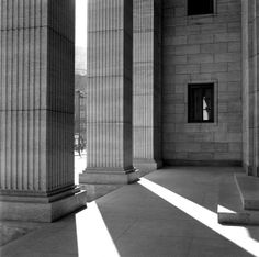 an empty room with columns and windows on the wall, in black and white photo