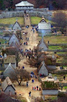 an aerial view of a village with people walking on the path and buildings in the background