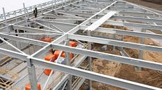 workers are standing on the roof of a building under construction