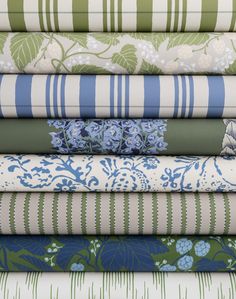 a stack of different colored fabrics with flowers and leaves on them, all in various colors