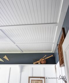 the ceiling is painted blue and has white paneling on it, along with some baseball bats