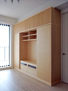 an empty room with wooden shelves and sliding glass doors