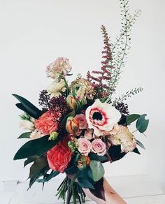 a vase filled with lots of flowers on top of a table