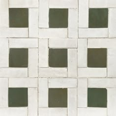 a white and green tiled wall with squares