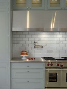 a stove top oven sitting inside of a kitchen next to a counter and cupboards