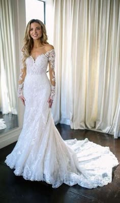 a woman in a white wedding dress posing for the camera