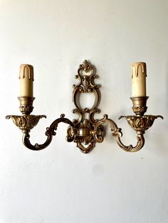 two wall sconces mounted to the side of a white wall