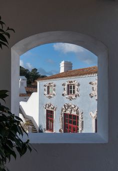 an arched window view of a building with red doors