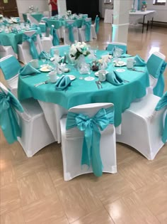 the tables are set up with blue sashes and white tablecloths for an elegant wedding reception