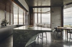 a large kitchen with an island counter top next to a dining room table and chairs