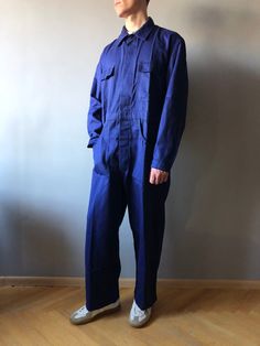 Workwear Pants / Work Coveralls / French Chore Pants / French Workwear / Size M-L This vintage coveralls in good unuse condition, dark spots left from storage (last photo) - made in Belgium - color - Navy Blue - 4 front pockets  - 1 back pockets - 2 cuff steel buttons - 7 steel buttons at front - material - sanforized cotton - label size - 52 (fit size M/L, watch measurements) FLAT Measurements: Shoulders : 51cm Chest (underarm to underarm) : 59cm Sleeve : 64cm Length(back) : 90cm Waist : 55cm + Retro Cotton Overalls With Relaxed Fit, Cotton Utility Overalls, Utility Cotton Overalls Pants, Workwear Overalls With Bib Front And Pockets, Utility Style Bib Front Bottoms For Workwear, Retro Workwear Jumpsuits And Rompers, Retro Style Workwear Overalls And Rompers, Utility Bib Front Bottoms For Workwear, Bib Front Overalls With Pockets For Workwear