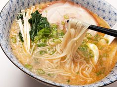 a bowl of soup with noodles and greens