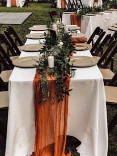 the table is set with plates and place settings for an outdoor wedding or party event