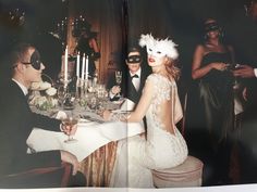 a man and woman sitting at a dinner table with masks on their faces as they talk to each other