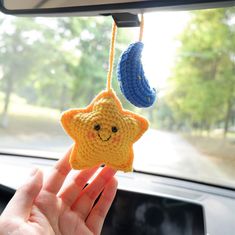 someone is holding up a crocheted star ornament in their car window