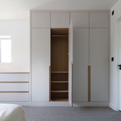 an empty bedroom with white walls and closets