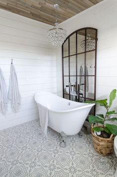 a white bath tub sitting next to a toilet in a bathroom