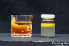 two glasses filled with liquid sitting next to each other on top of a gray counter