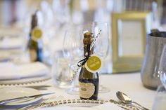 a bottle of wine sitting on top of a table next to glasses and silverware