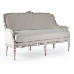 an old style couch with white upholstered fabric