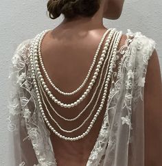 the back of a woman's dress with pearls on it