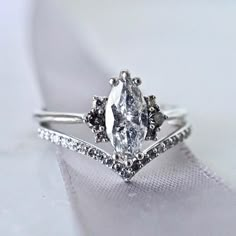 a close up view of a diamond ring on top of a white satin material cloth