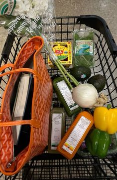 a shopping cart filled with groceries and vegetables