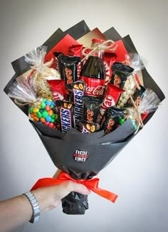 a person holding a bouquet of candy and candies