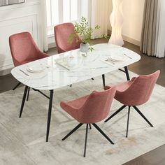 a dining room table with pink chairs and a white rug in front of the window