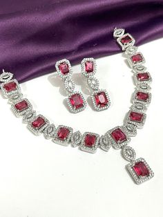 Gorgeous fine quality replica diamond and RUBY red  studded necklace with white gold rhodium plating and matching Earrings Item contains: Necklace and earrings AAA quality cubic zirconia used. Highest quality and craftsmanship Necklace Fitting is adjustable Earrings Closure: Pushback Necklace Closure: chain with Hook Details-  -Handmade item -Delivery from a small business in India -Materials: white rhodium, stones, cz, zircon, American diamond -Jewellery type: Earrings, Necklace -Style: Art dec Dazzling Ruby Jewelry For Gifts, Hallmarked Cubic Zirconia Jewelry For Party, Elegant Red Jewelry With Diamond Accents, Formal Ruby Jewelry With Sparkling Stones, Dazzling Ruby Jewelry Sets For Anniversary, Pink Ruby Necklace For Formal Occasions, Red Hand Set Necklaces For Anniversary, Red Costume Jewelry For Anniversary, Fine Red Diamond Jewelry